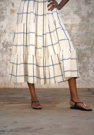 Person wearing a plaid skirt with a neutral background
